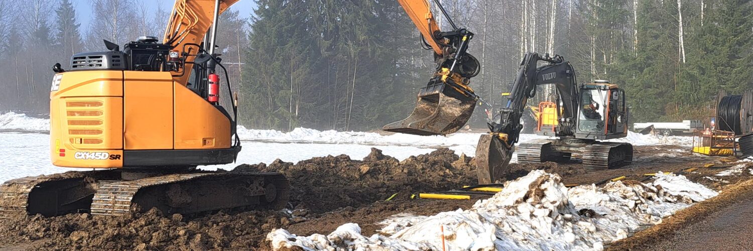 Maakaapelointia Karviassa kevätsäässä. Kuvassa kaksi kaivinkonetta kaivaa maata.